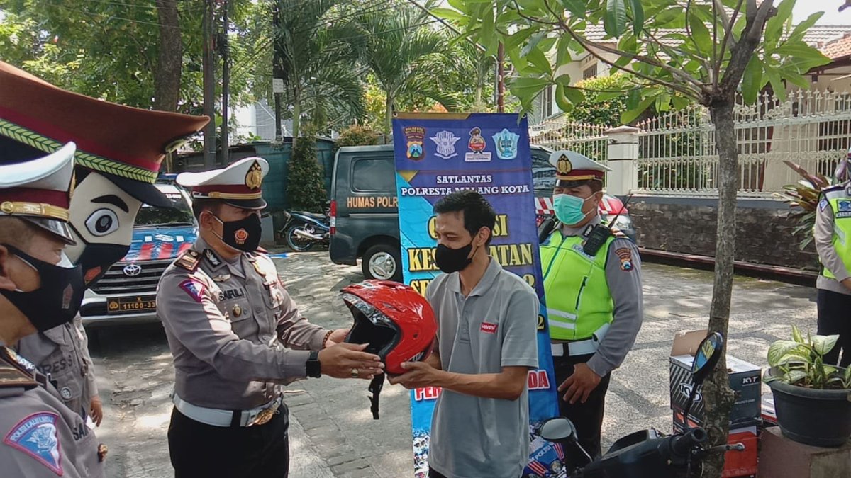 Wujudkan Keselamatan Untuk Kemanusiaan, Polresta Malang Kota Bagikan Helm dan Masker