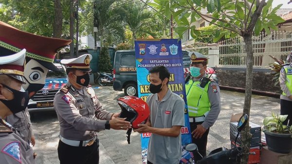 Wujudkan Keselamatan Untuk Kemanusiaan, Polresta Malang Kota Bagikan Helm dan Masker